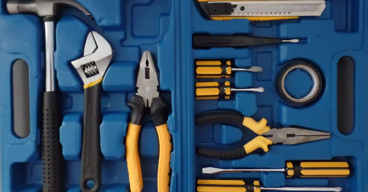 blue toolbox case filled with hammer pliers screwdrivers box cutter and tape