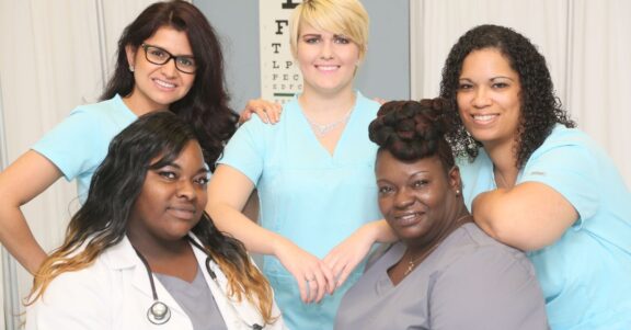 group of nurses healthcare pros in front of medical room divider sheet