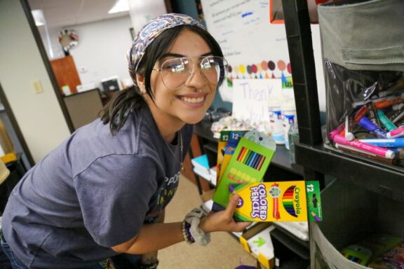 smiling teacher at Aurora Public Schools Foundation Educator Emporium selecting markers for students