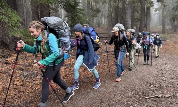 student group and Cascades Academy staff hiking through woods along path