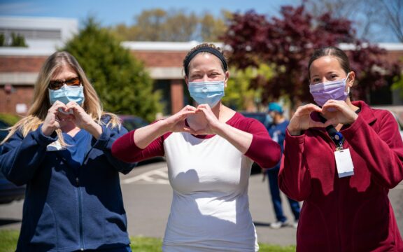 three nurses making hearts with hands wearing masks outside Photo by Rusty Watson yIGinlYA6t8 Unsplash