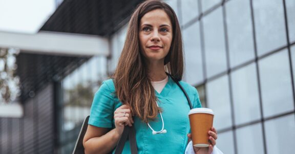 traveling nurse leaving town for next assignment carrying bag shirt coffee stethoscope outside hospital