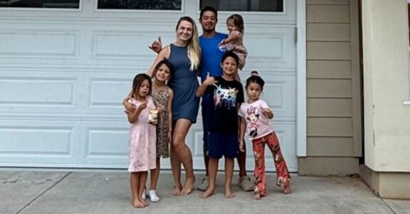 veteran family standing in front of home smiling