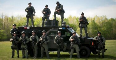 Virginia Beach Police Dept officers in gear next to swat vehicle for foundation grant