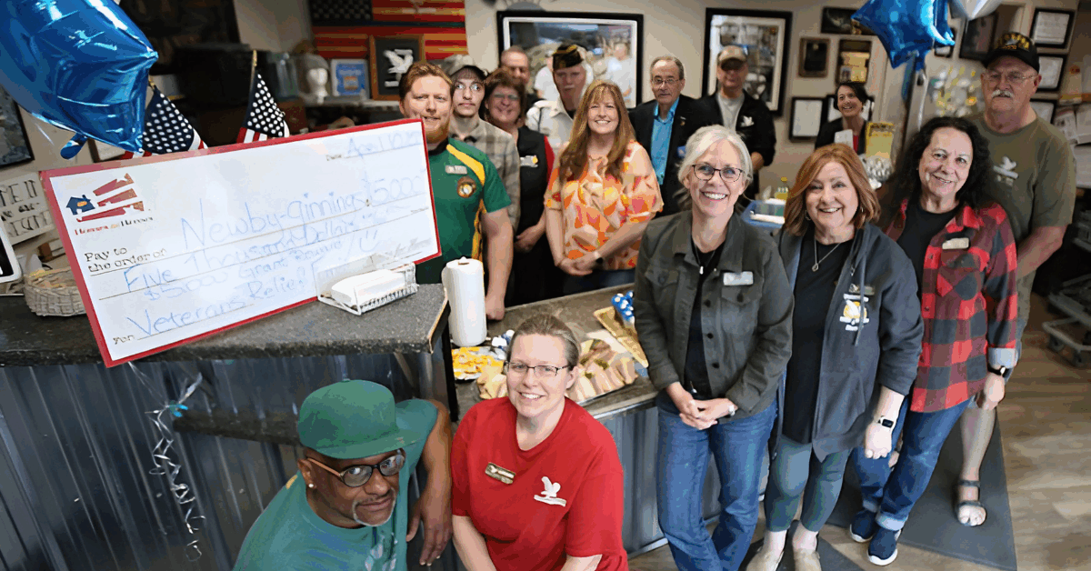 Newby-ginnings team facility posing with Homes for Heroes Foundation grant check